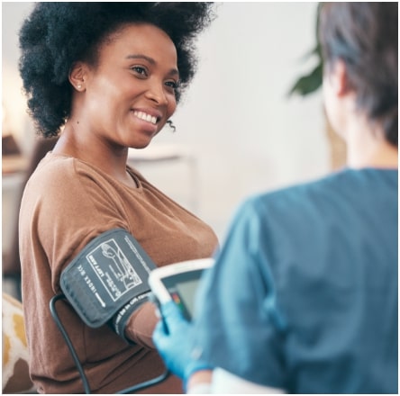 A woman is taking her blood pressure in a doctor's office.